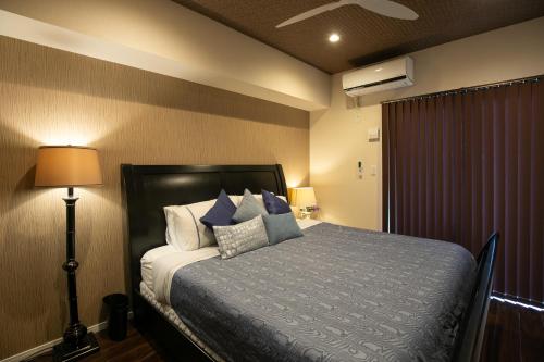 a bedroom with a bed with blue and white pillows at Ocean Resort House 205 in Onna