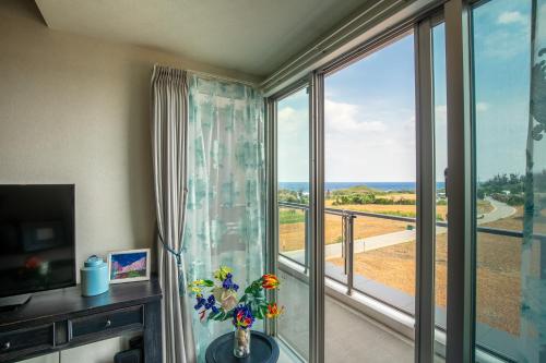 a room with a large window with a view of the ocean at Ocean Resort House 205 in Onna