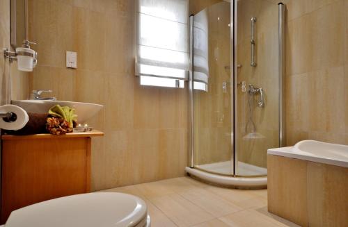 a bathroom with a shower and a toilet and a sink at Duplex St Julians Central Penthouse in St. Julianʼs