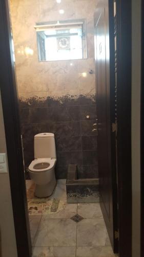 a bathroom with a toilet and a window at Guesthouse different in Tbilisi City