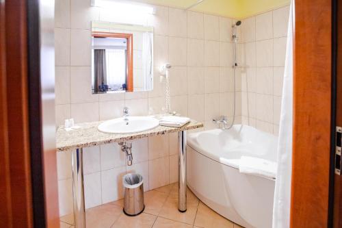a bathroom with a sink and a bath tub at Business Hotel Vega Wrocław in Wrocław