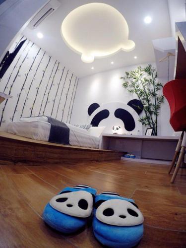 a bedroom with a panda bear bed and a pair of slippers at The Tree Hotel in Muar