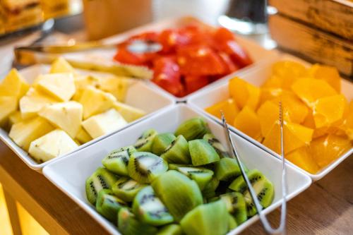 three trays of different types of fruit on a table at Business Hotel Vega Wrocław in Wrocław