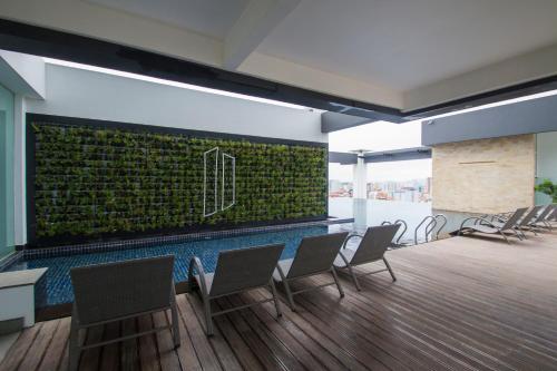 a conference room with chairs and a green wall at Naki Suites @ Silvertown in Phnom Penh