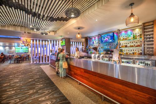 a group of people standing at a bar at Nightelier Narrabeen in Narrabeen