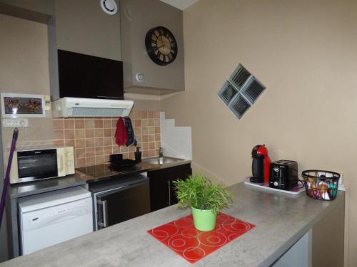 une cuisine avec un comptoir avec une horloge murale dans l'établissement Chez Odile, à Sigean