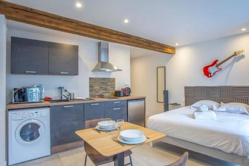 une chambre avec un lit et une table et une cuisine dans l'établissement R’Studio 25 Hyper Centre, à Grenoble