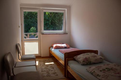 ポッドンビエにあるDomek letniskowyのベッド2台と窓が備わる小さな客室です。