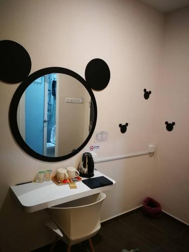 a bathroom with a round mirror on the wall at The Tree Hotel in Muar