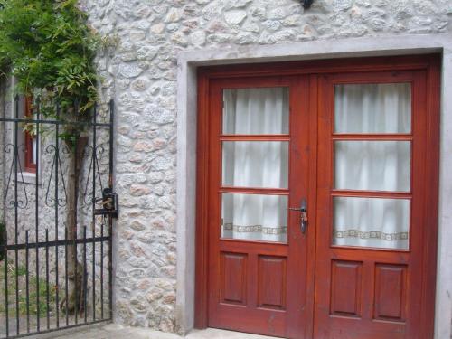 a red door on a stone building with a gate at Casa Xan da Pena in Villarmayor