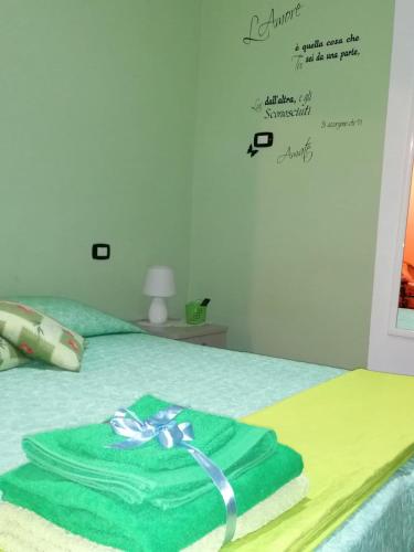 a green towel sitting on top of a bed at B&B La Rosa dei Venti in Acri