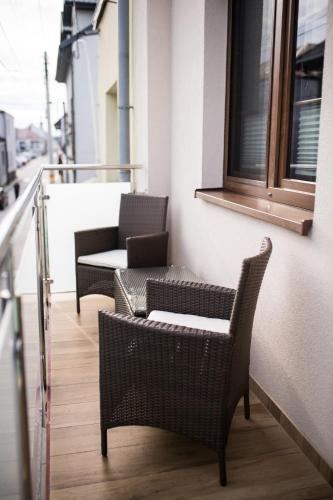 a balcony with two chairs and a window at Apartamenty Królewskie in Chęciny