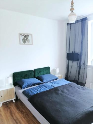a bedroom with a large bed with blue sheets at Bezpieczna Przystań - Apartamenty-balia, sauna, narty in Uherce Mineralne