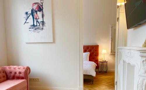 リエパーヤにあるAngel apartmentのピンクのソファ付きのリビングルーム、ベッドルーム1室が備わります。