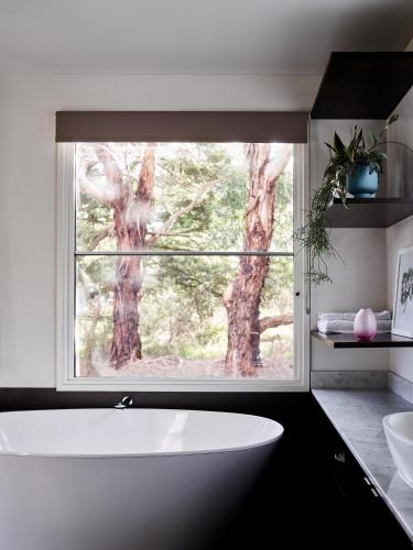 a bathroom with a large window and a white tub at Hart's Farm in Shoreham