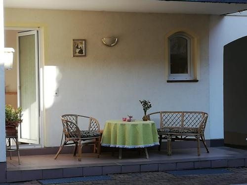 Pension Am Rosental Merseburg في مرسيبورغ: طاولة مع قماش الطاولة الخضراء على الفناء