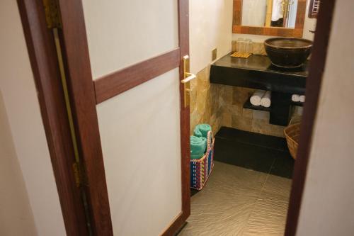 uma porta que leva a uma casa de banho com lavatório em ViewPoint Ecolodge em Nyaung Shwe