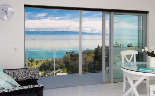 a living room with a view of the ocean at Aqua-Heights Apartment in Nelson