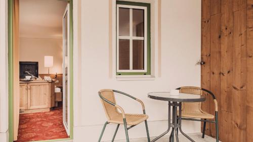 a table and chairs in a room with a window at Hotel Auhof Kappl in Kappl