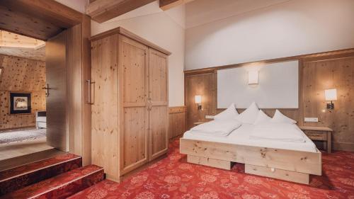 a bedroom with a bed with a wooden headboard at Hotel Auhof Kappl in Kappl