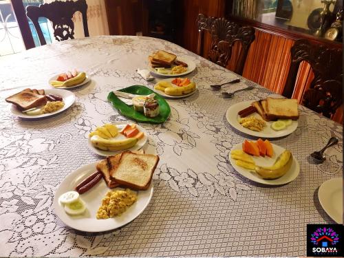 a table with plates of breakfast food on it at Sobaya in Anuradhapura