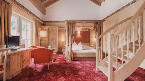 a bedroom with a bed and a staircase in a room at Hotel Auhof Kappl in Kappl