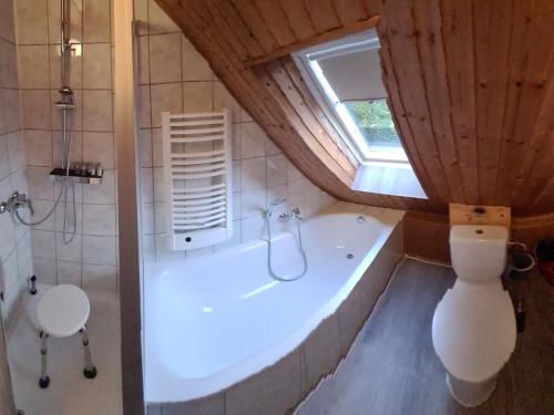 y baño con bañera, aseo y lavamanos. en Ferienwohnung-32609 W4, en Hüllhorst