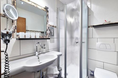 a bathroom with a sink and a shower at Hotel Engel - Familotel Hochschwarzwald in Todtnauberg