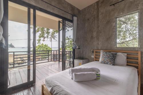 a bedroom with a bed with a view of the ocean at New Heaven Dive School and Resort in Ko Tao