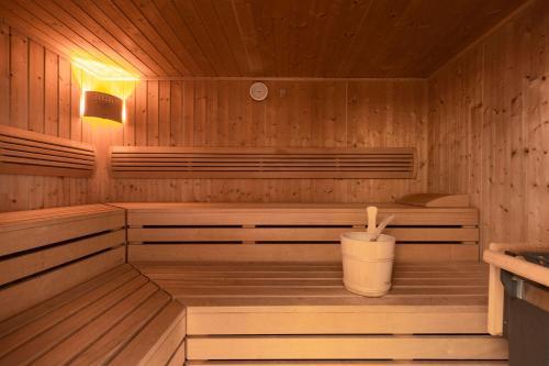 a wooden sauna with a bucket in it at Hotel Auhof Kappl in Kappl