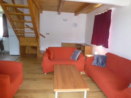 a living room with two orange couches and a wooden table at vila krkonoše in Cerny Dul