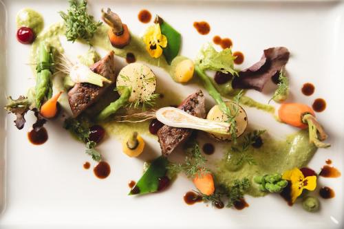 a white plate of food with vegetables on it at Hotel Auhof Kappl in Kappl