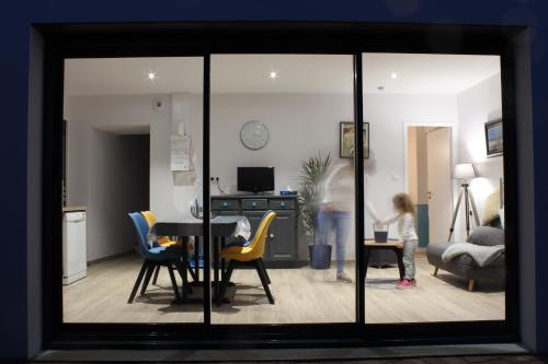 une petite fille debout dans un salon avec une table et des chaises dans l'établissement Gite Le Tiguidou, à La Verrie