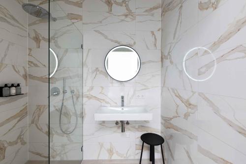 een badkamer met een wastafel en een spiegel bij Anegang Boutique Appartement in Haarlem