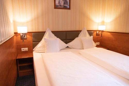 a bedroom with two beds with white sheets and two lamps at Business Hotel Vega Wrocław in Wrocław