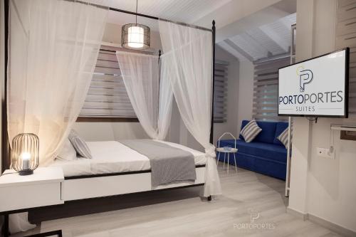 a bedroom with a canopy bed and a blue couch at PORTO PORTES suites in Nea Potidaea