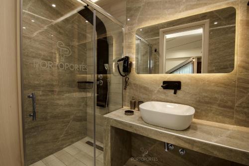 a bathroom with a sink and a shower at PORTO PORTES suites in Nea Potidaea