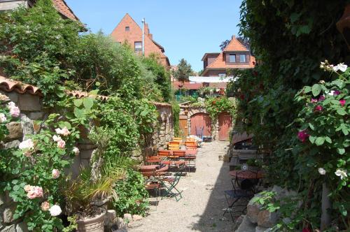 einen Garten mit Stühlen, Tischen und Blumen in der Unterkunft Schillers Stadthaus in Hitzacker
