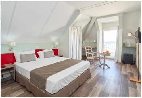 sypialnia z dużym łóżkiem, stołem i krzesłami w obiekcie Hotel Austral w mieście Saint-Denis