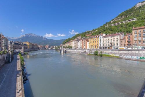 une rivière dans une ville avec des bâtiments et un pont dans l'établissement R’Studio 18 Hyper Centre, à Grenoble