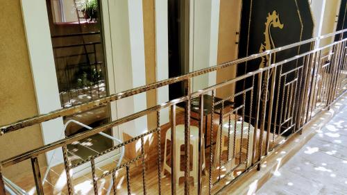 a dog sitting behind a metal fence in a hallway at Dracena Guesthouse in Ravda