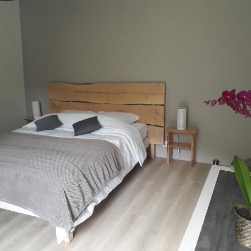 une chambre avec un grand lit avec une tête de lit en bois dans l'établissement la sereine, à Pech