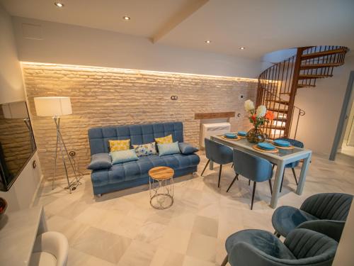 sala de estar con sofá azul y mesa en Casas de Sevilla - Apartamentos Vidrio 7, en Sevilla