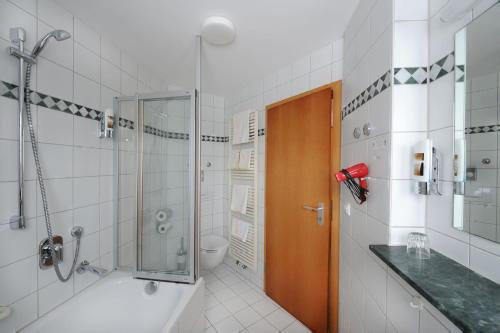 La salle de bains est pourvue d'une douche, d'un lavabo et de toilettes. dans l'établissement Landgasthof Hölzle, à Waldstetten
