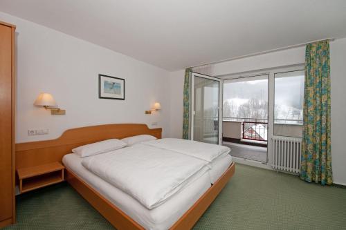 Un dormitorio con una cama y una ventana grande. en Landgasthof Hölzle, en Waldstetten