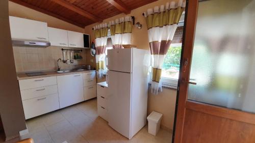 kuchnia z białymi szafkami i lodówką w obiekcie Casa Marina bariere free w Rovinj