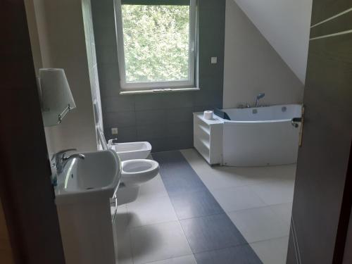 a white bathroom with two toilets and a sink at Domek na Mazurach-Piasutno in Piasutno