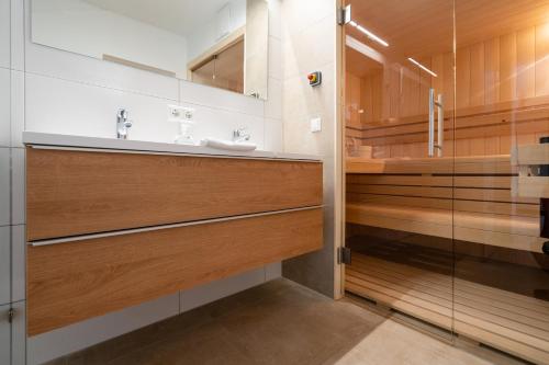 a bathroom with a sink and a glass shower at AmThumersbach in Zell am See