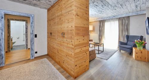 a large wooden wall in a room with a blue chair at Landhotel zum Bad in Krün