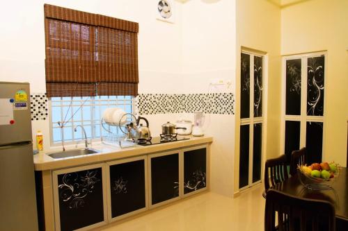 O bucătărie sau chicinetă la Homestay Hj Esmon Parit Raja UTHM